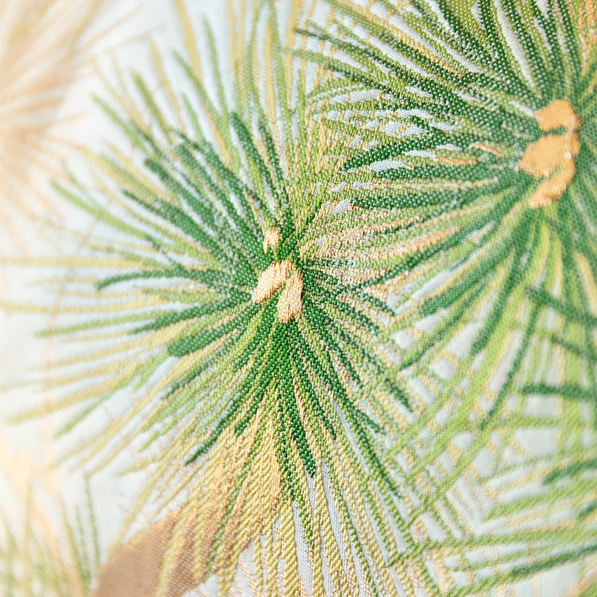 Close-up of green pine needles woven into vintage Japanese fukuro obi silk