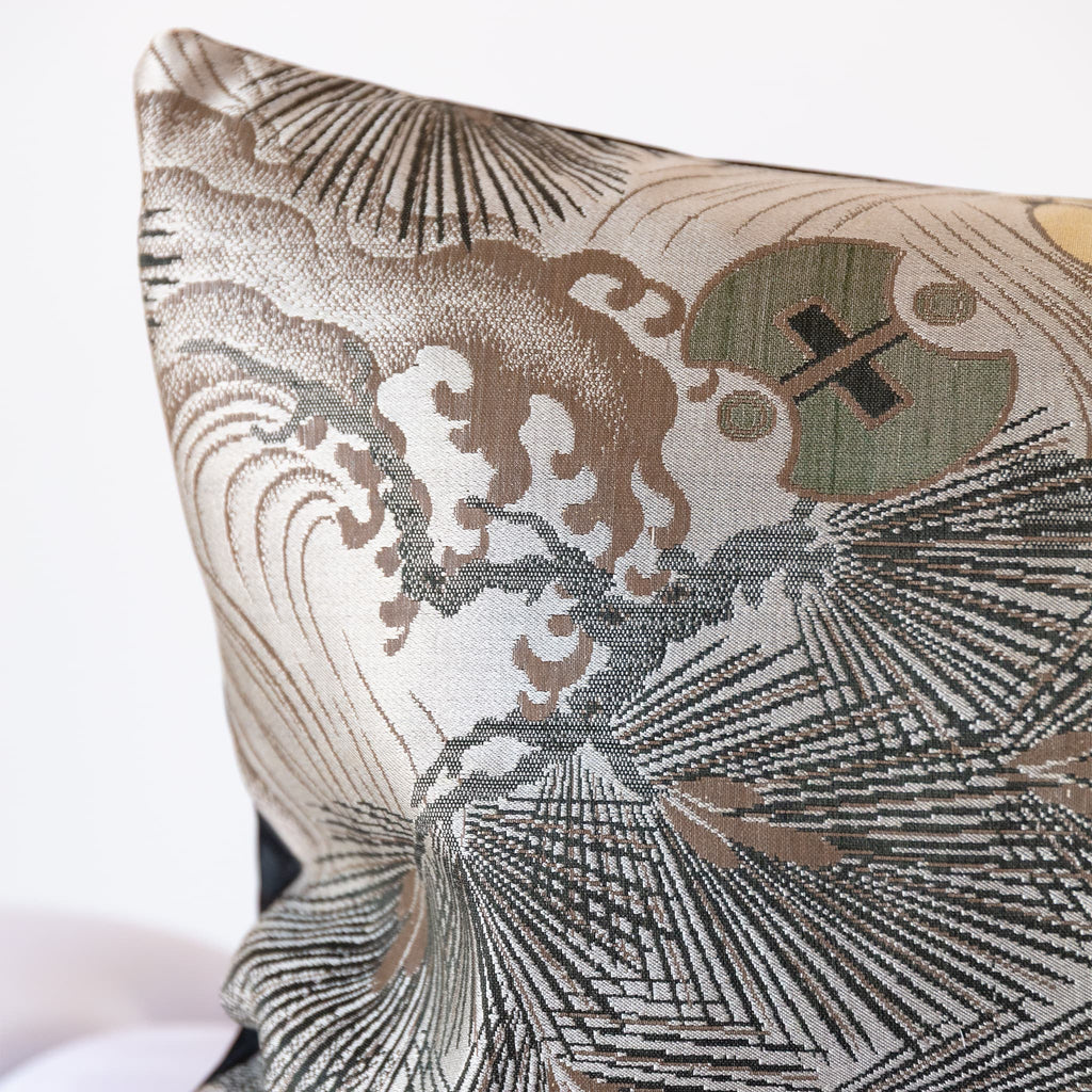 Corner detail of grey silk bolster cushion showing woven Maru Obi textile with pine and wild wave motifs