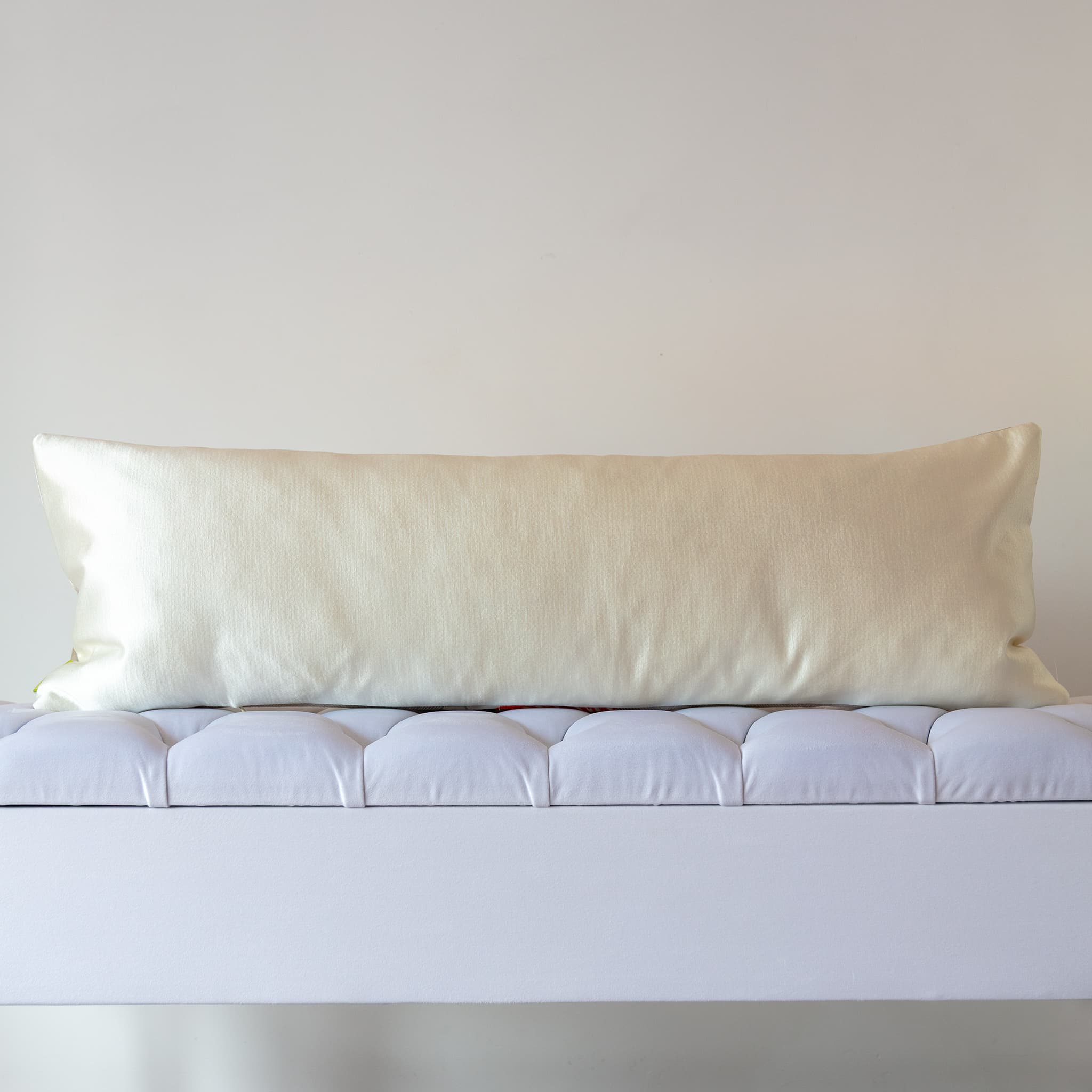 Hammered pearl satin reverse of long silver silk bolster cushion, cool lustrous counterpoint to the flame orange front
