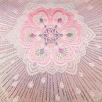 Detail of pink floral design and silver starburst accent on the obi cushion.