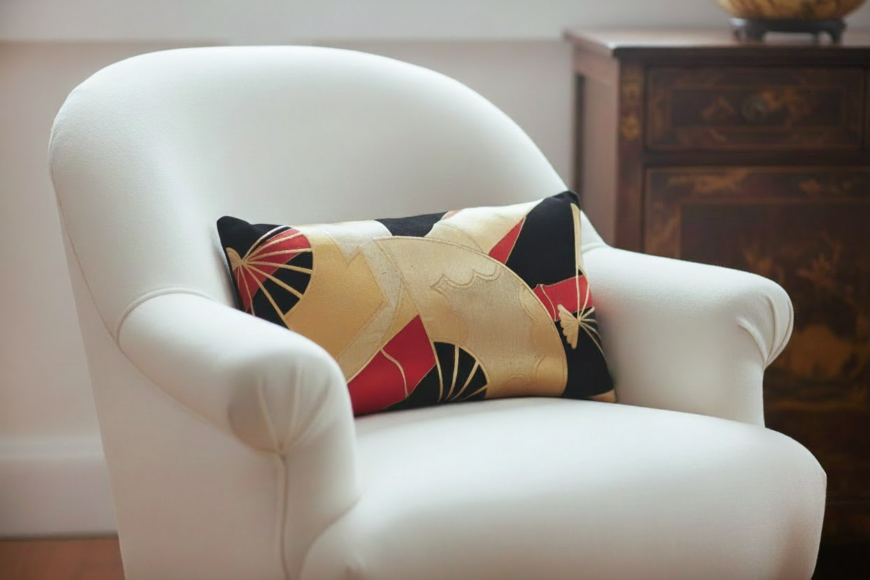Rectangular obi silk cushion in black with gold fans on a white upholstered chair
