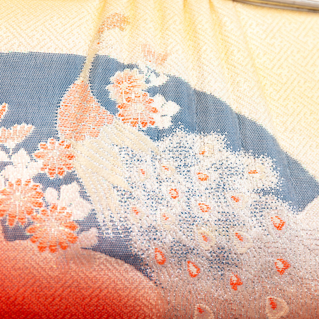 Close up detail of the vintage Japanese bag design showing woven peacock in gold over a black fan and geometric pattern design.