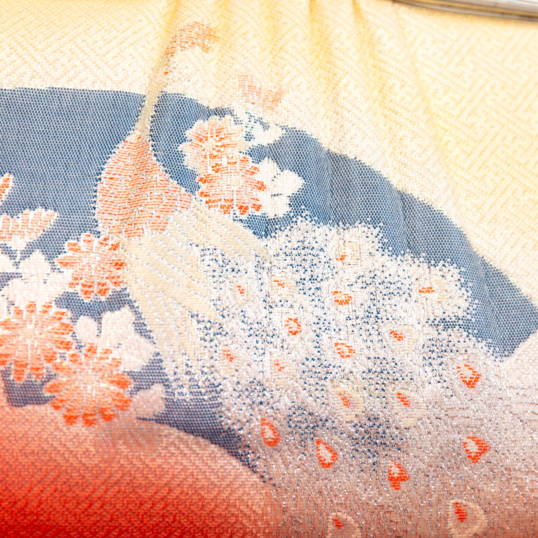 Close up detail of the vintage Japanese bag design showing woven peacock in gold over a black fan and geometric pattern design.