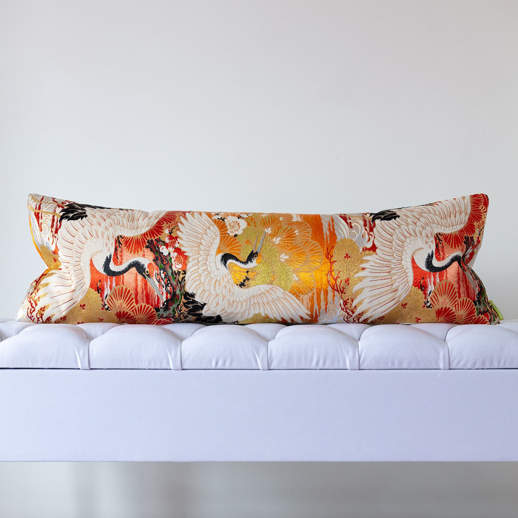 Japanese silk bolster cushion with soaring cranes and pine fans on a golden and burnt orange vintage Maru Obi ground