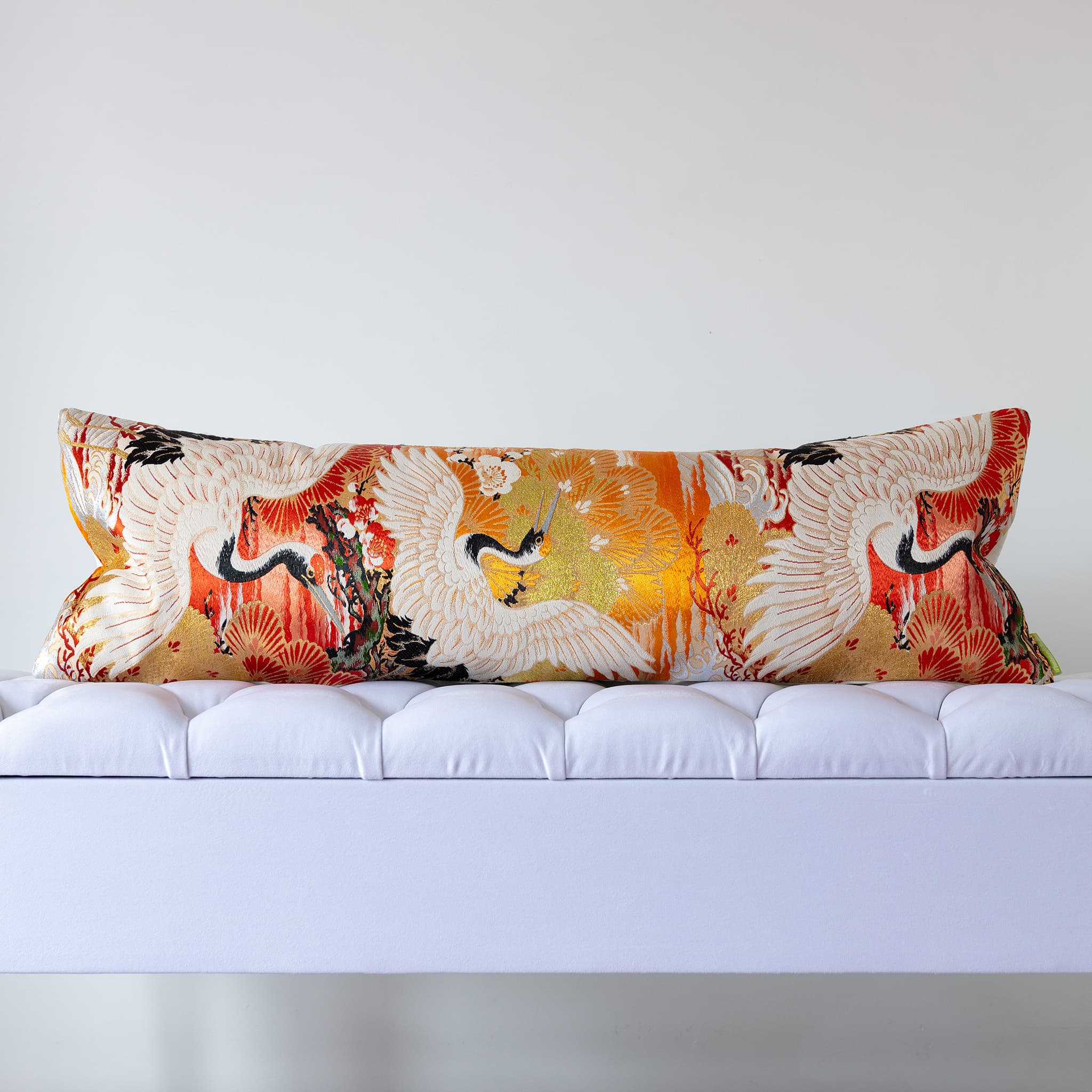 Japanese silk bolster cushion with soaring cranes and pine fans on a golden and burnt orange vintage Maru Obi ground
