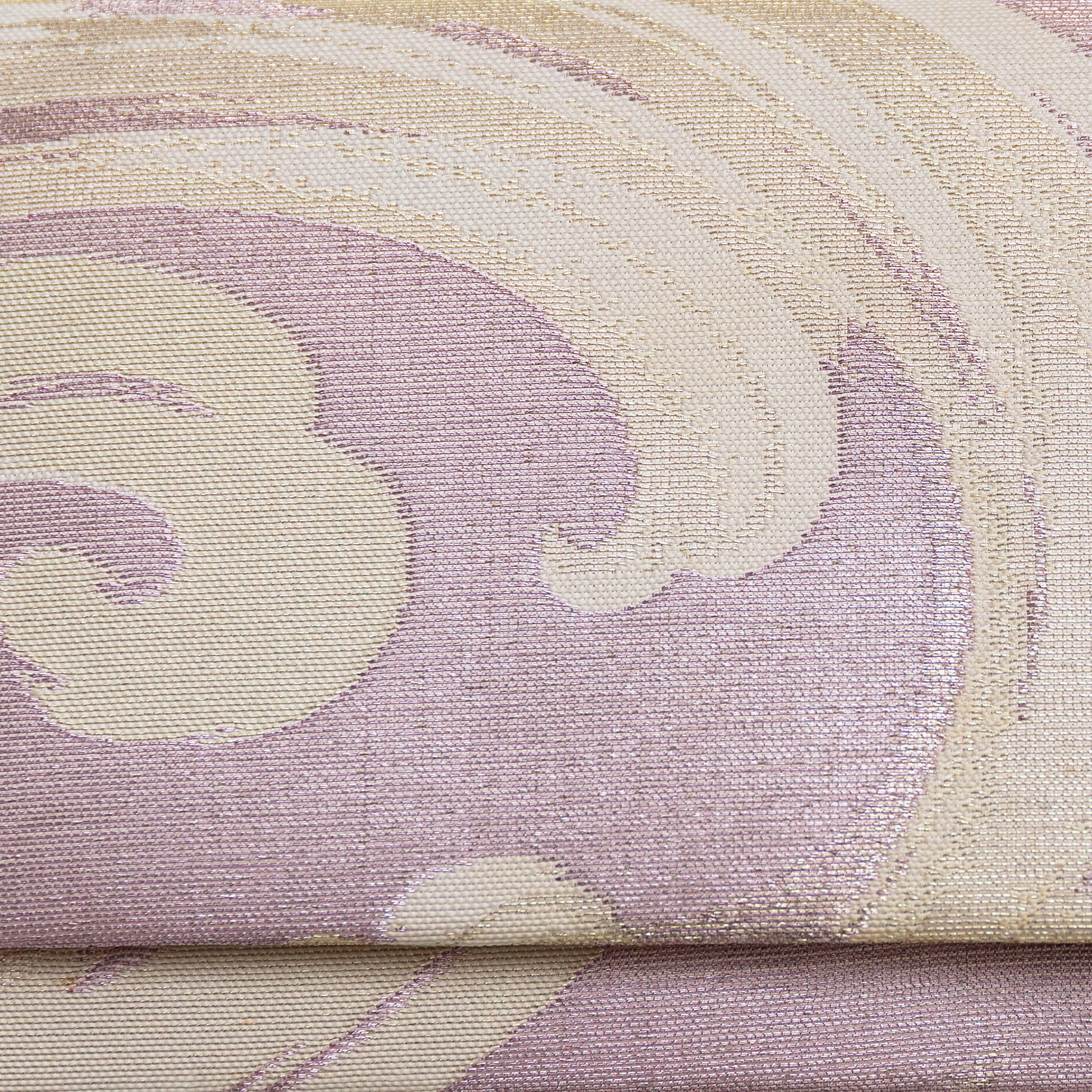 Close up detail of lilac woven silk vintage clutch bag surface showing cream and silver woven silk waves pattern over lilac pale pink base.