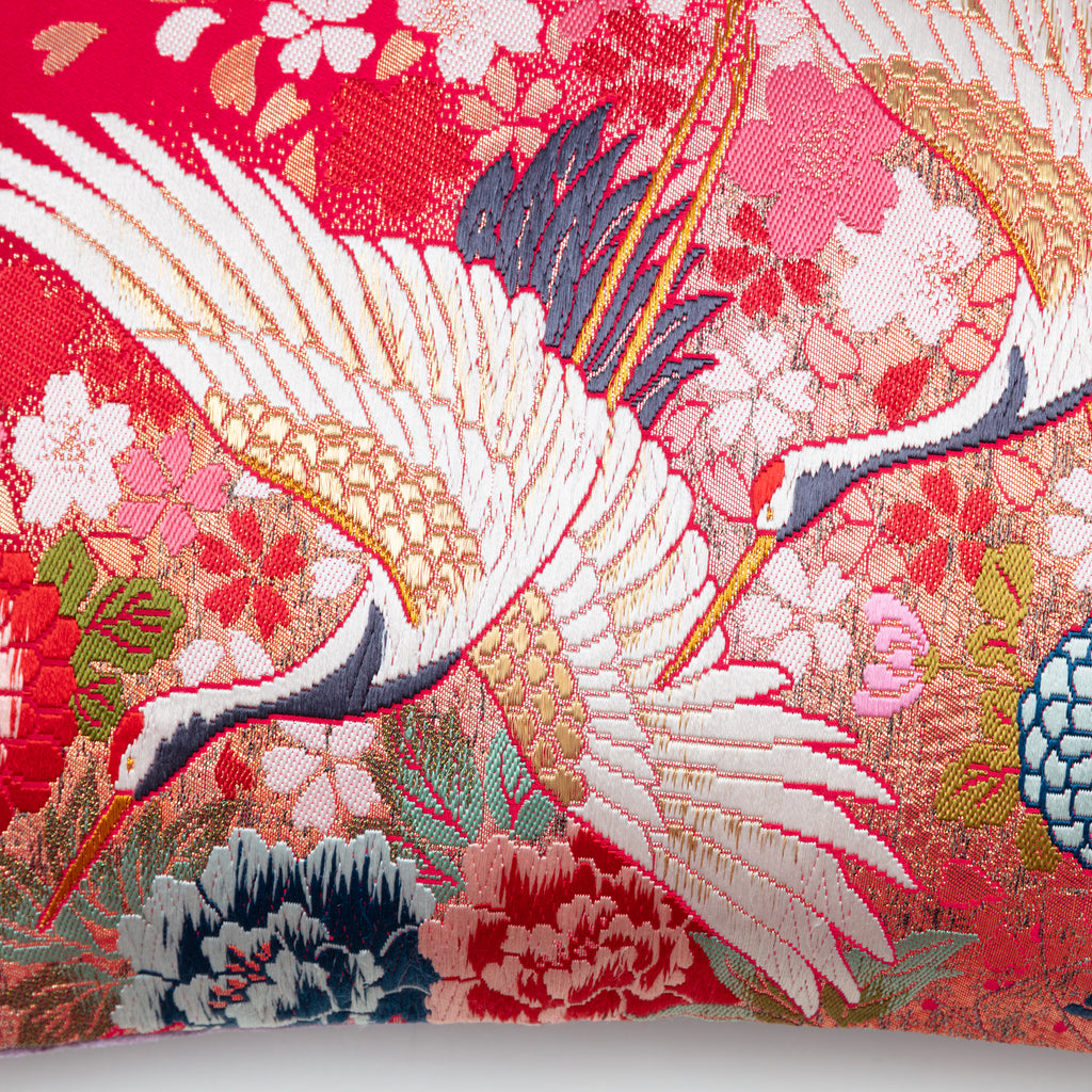 Close-up of the cushion's purple velvet fabric border and intricate flying cranes embroidery detail from a diagonal angle.