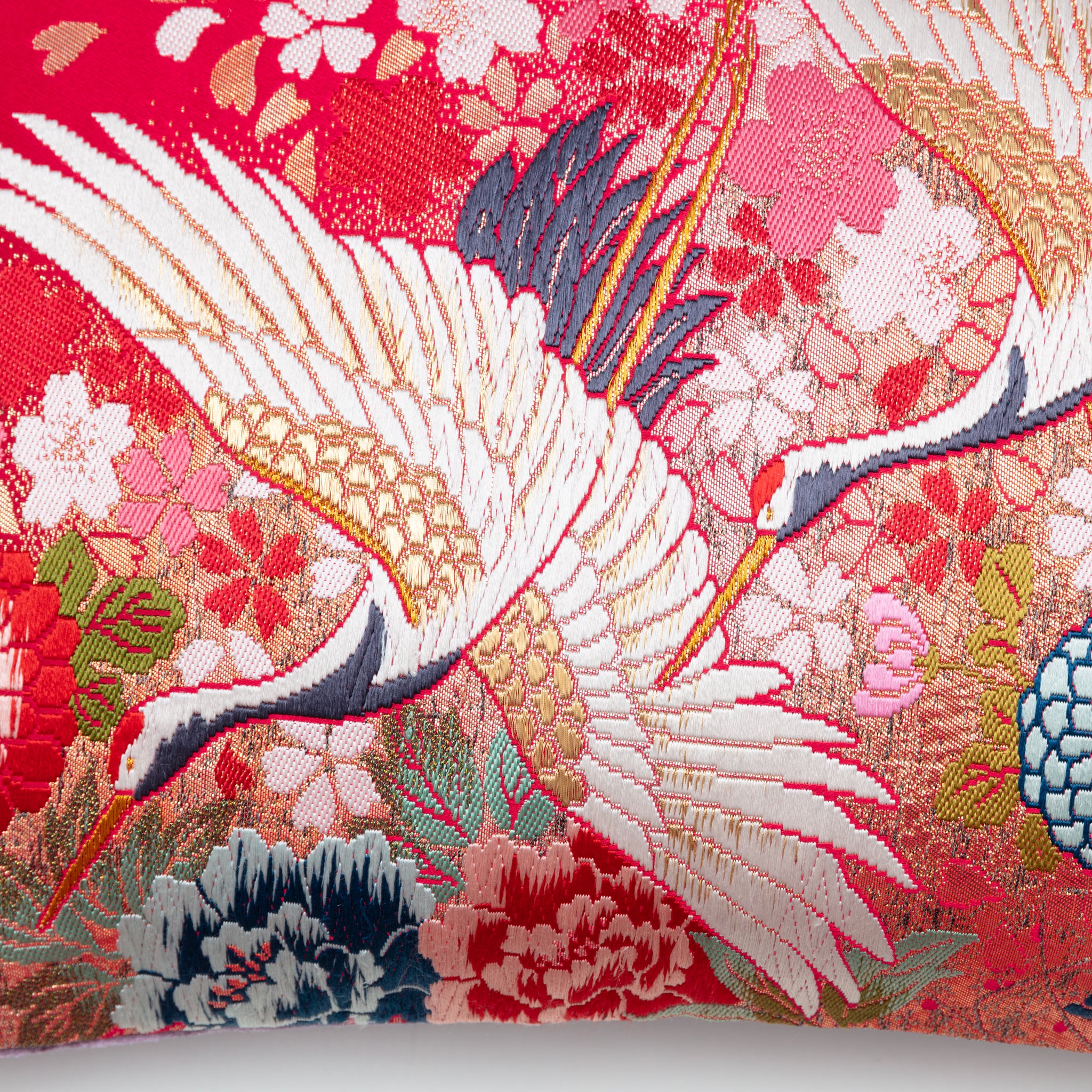 Close-up of the cushion's purple velvet fabric border and intricate flying cranes embroidery detail from a diagonal angle.