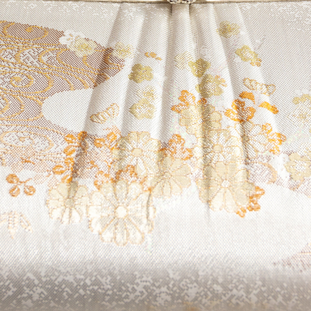 Close-up of the Ivory Silk Clutch's intricate kimono silk embroidery showcasing delicate floral patterns and subtle sheen