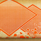 Close up vintage kimono silk brocade with metallic gold weave and orange silk geometric diamond shapes.