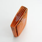 Side view of a bronze and gold vintage Japanese silk clutch bag showing the folded side panel.