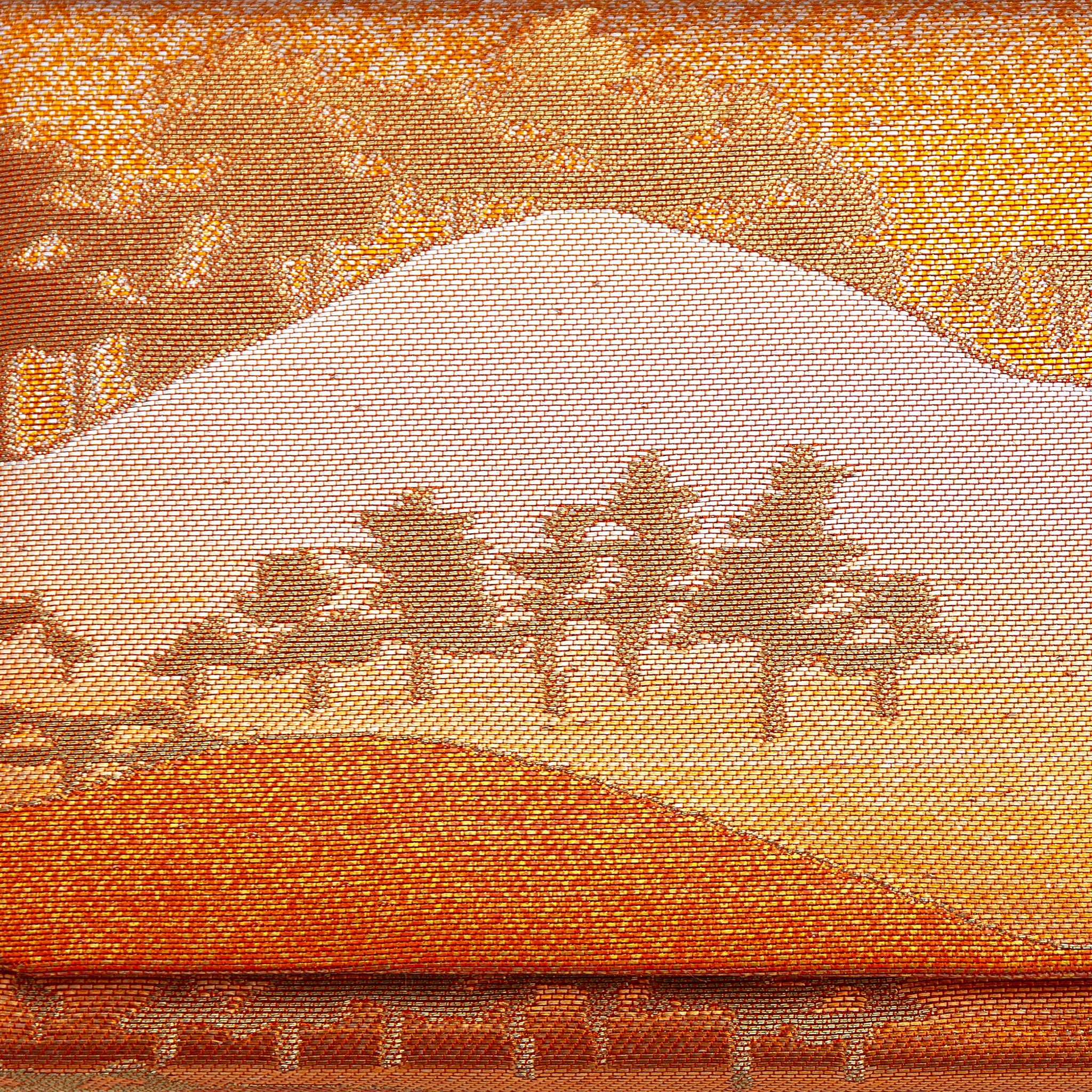 Close up of vintage kimono silk clutch with bronze, gold and orange metallic mountain and tree pattern.