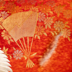 close up of vintage kimono silk with gold fans and flowers over mottle dyed red 