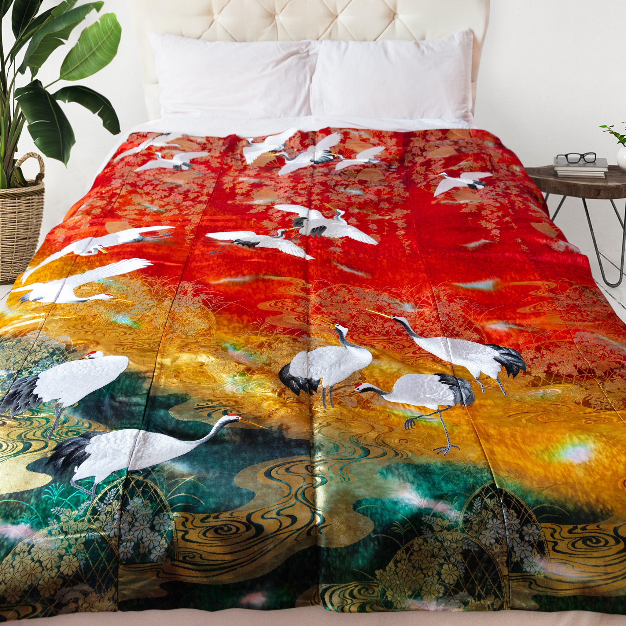 Vintage kimono silk throw with cranes and landscape pattern in red, gold and green on bed
