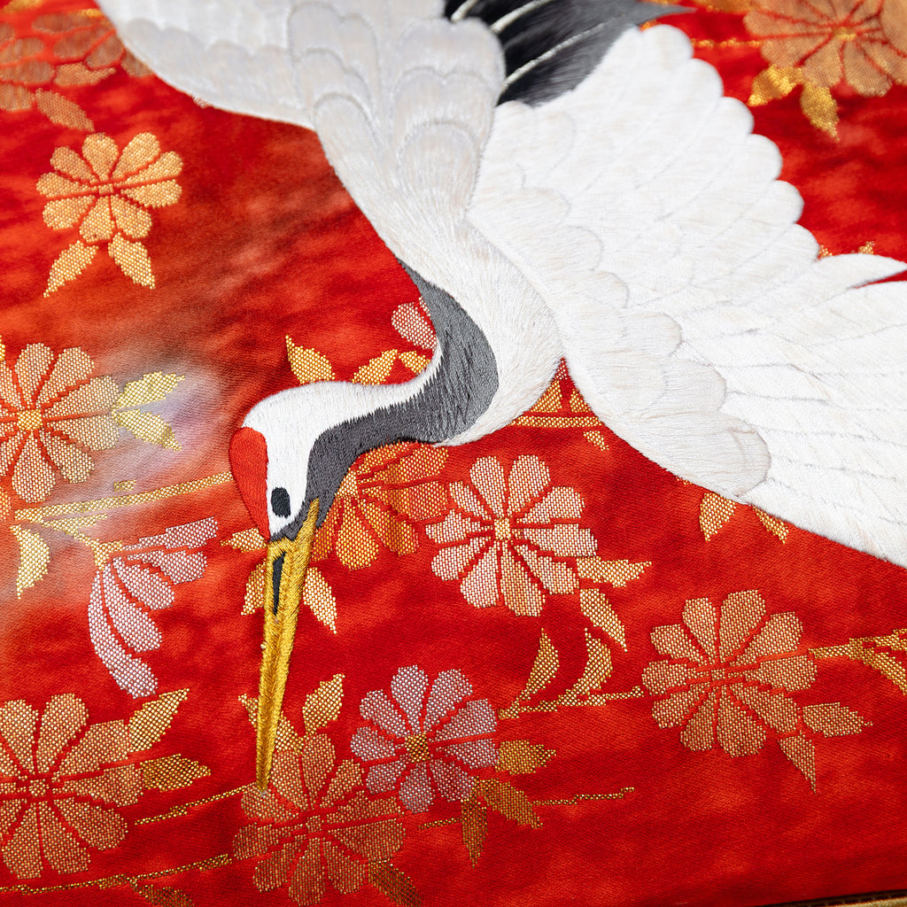 close up of vintage kimono silk showing white crane over red and gold flowers