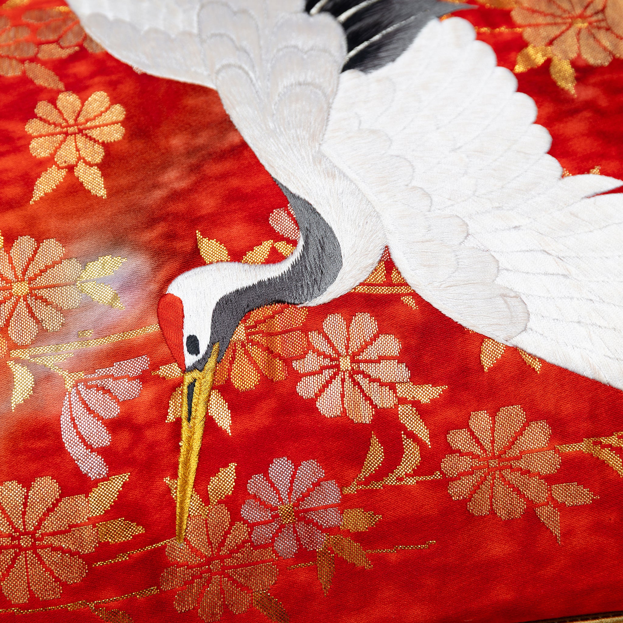 close up of vintage kimono silk showing white crane over red and gold flowers