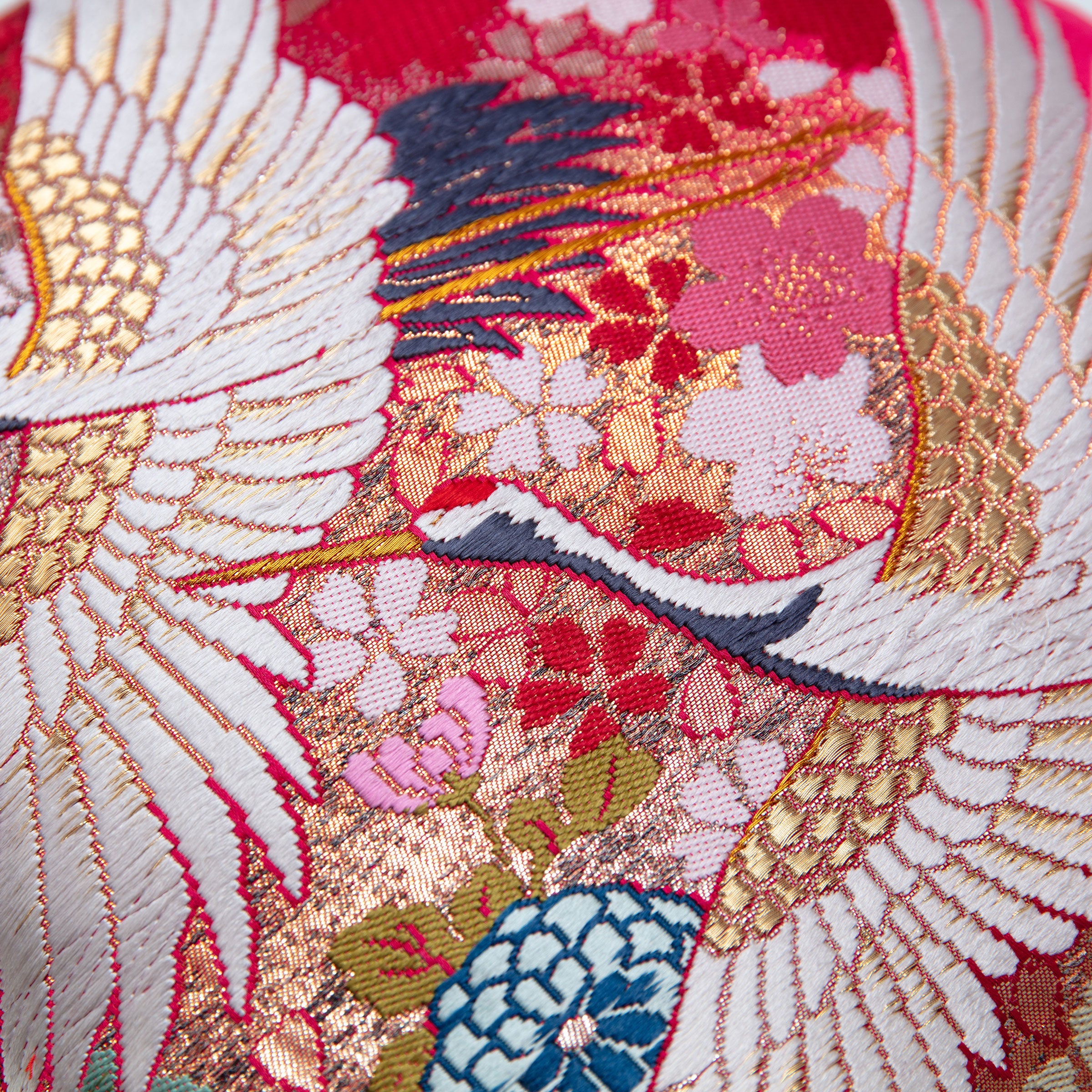 Close-up of cranes and metallic gold thread on a vintage Japanese uchikake silk cushion cover.