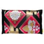 A rectangular throw pillow with a black silk base featuring a pink floral motif and metallic gold accents in a geometric pattern. Made from vintage Japanese obi silk.