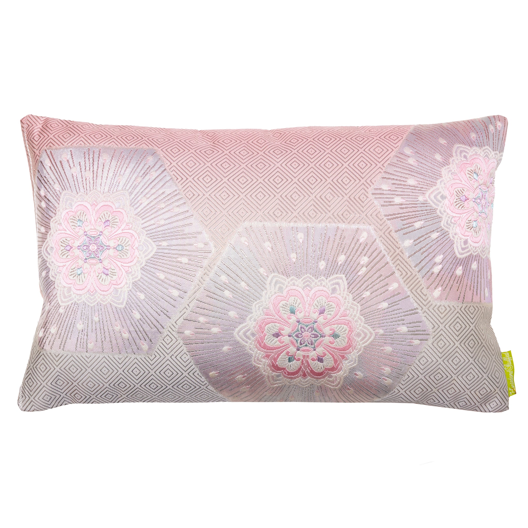 A rectangular silk cushion with a pink ombre background featuring silver hexagons and floral patterns, and a geometric pinebark diamond pattern.