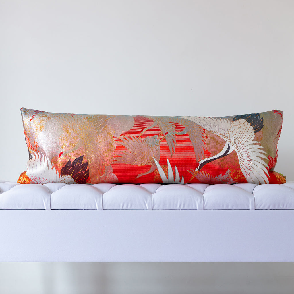 long bolster cushion made from vintage uchikake kimono silk in red with white cranes and silver clouds on a white bench