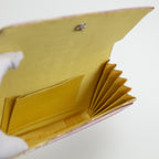 View looking down inside a vintage Japanese silk clutch bag with yellow silk lining, interior pocket and concertina fold side panel.