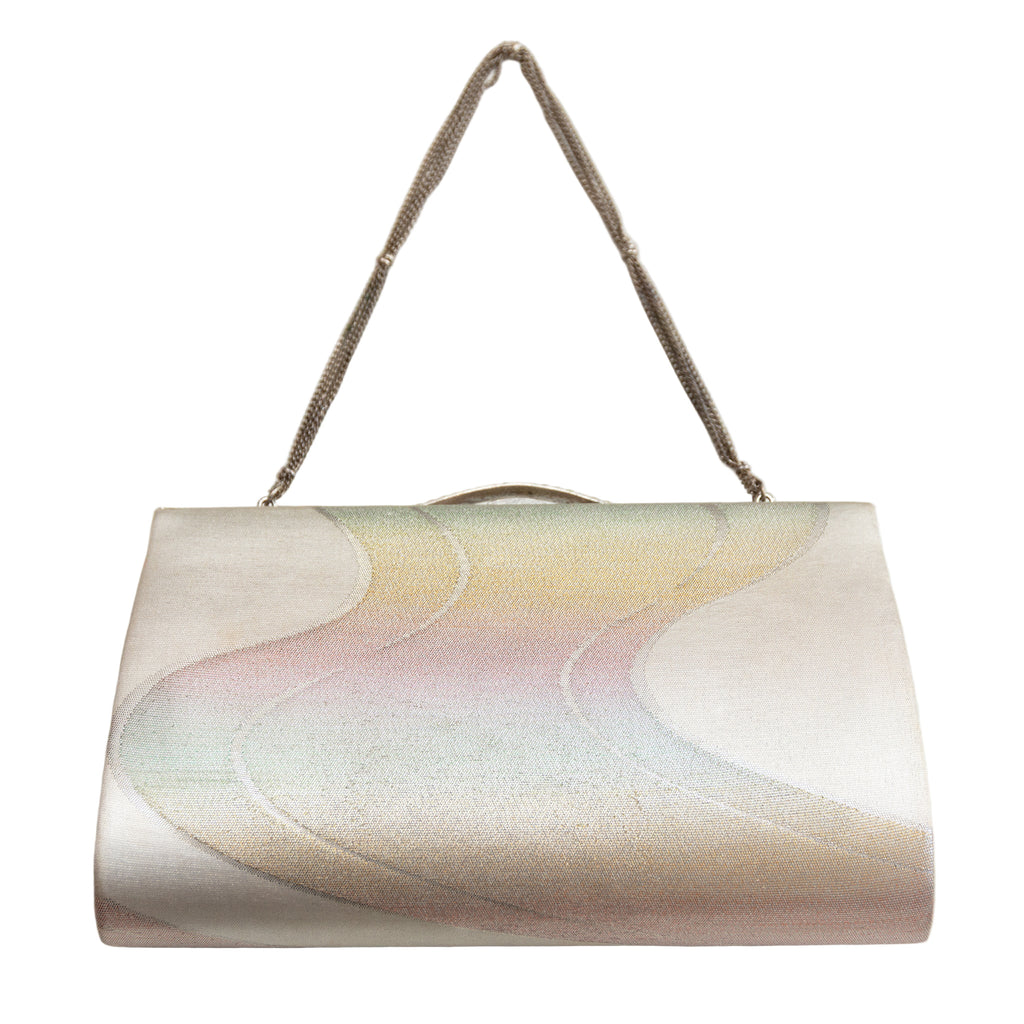 Reverse view of vintage Japanese silk clutch bag in rainbow river design, silver strap on white background.