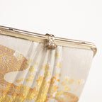 Detail shot of the filigree silver clasp on cream vintage Japanese clutch bag and the pleated structure detail on the front of the bag