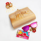 Vintage Japanese silk clutch bag with gold flowers and clasp on a white background with colourful accessories