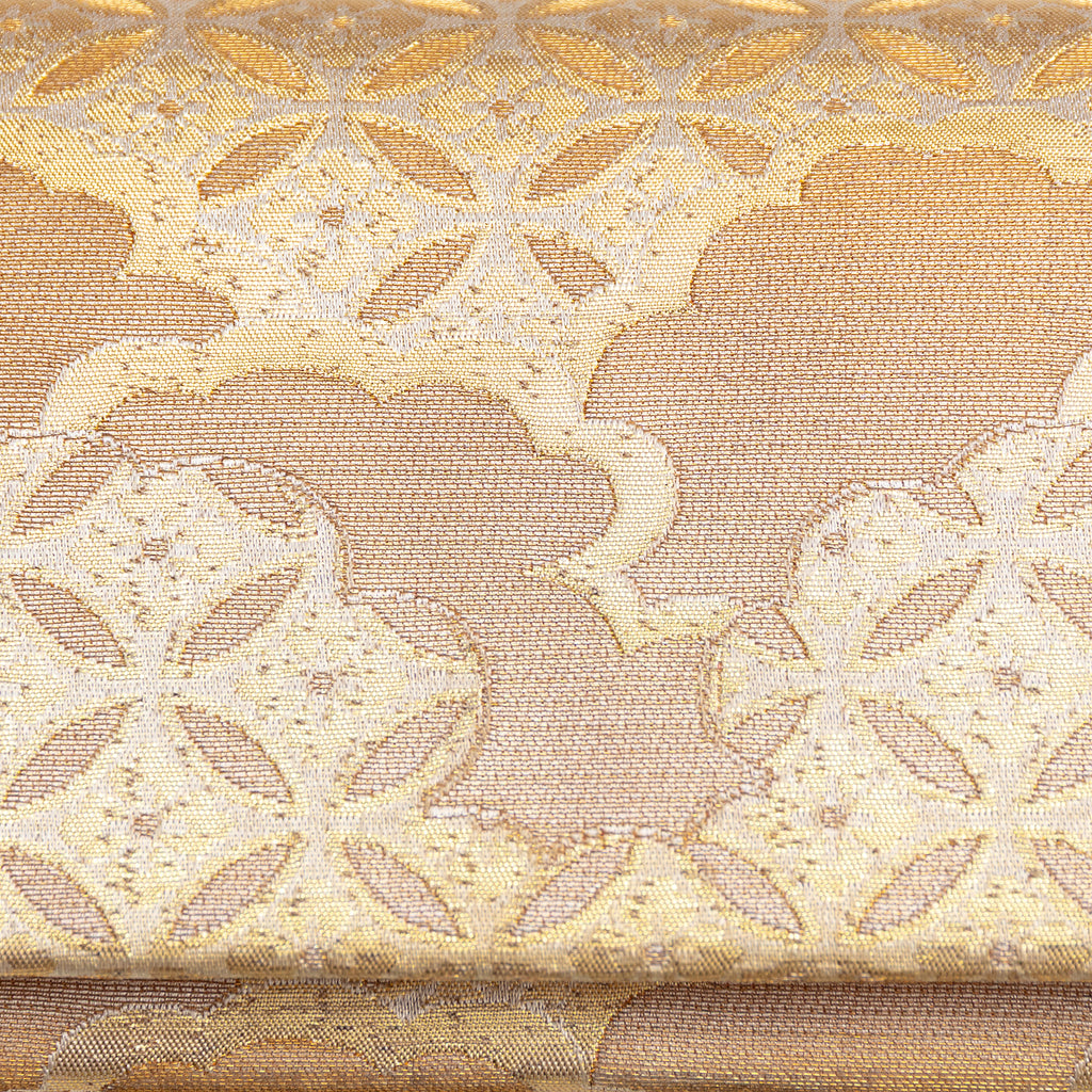 Close up of the shippo circle and clouds pattern on the front of a metallic gold vintage Japanese silk clutch bag.