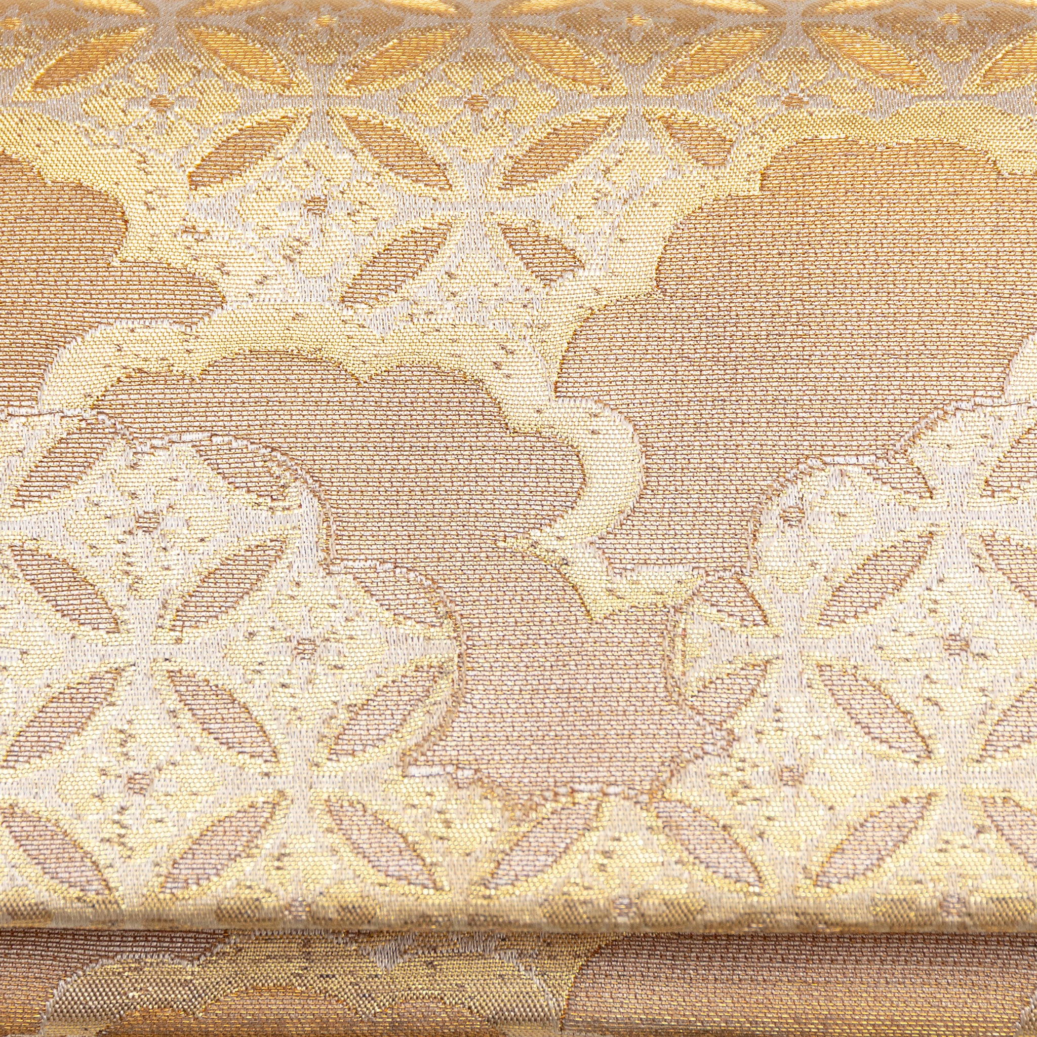 Close up of the shippo circle and clouds pattern on the front of a metallic gold vintage Japanese silk clutch bag.