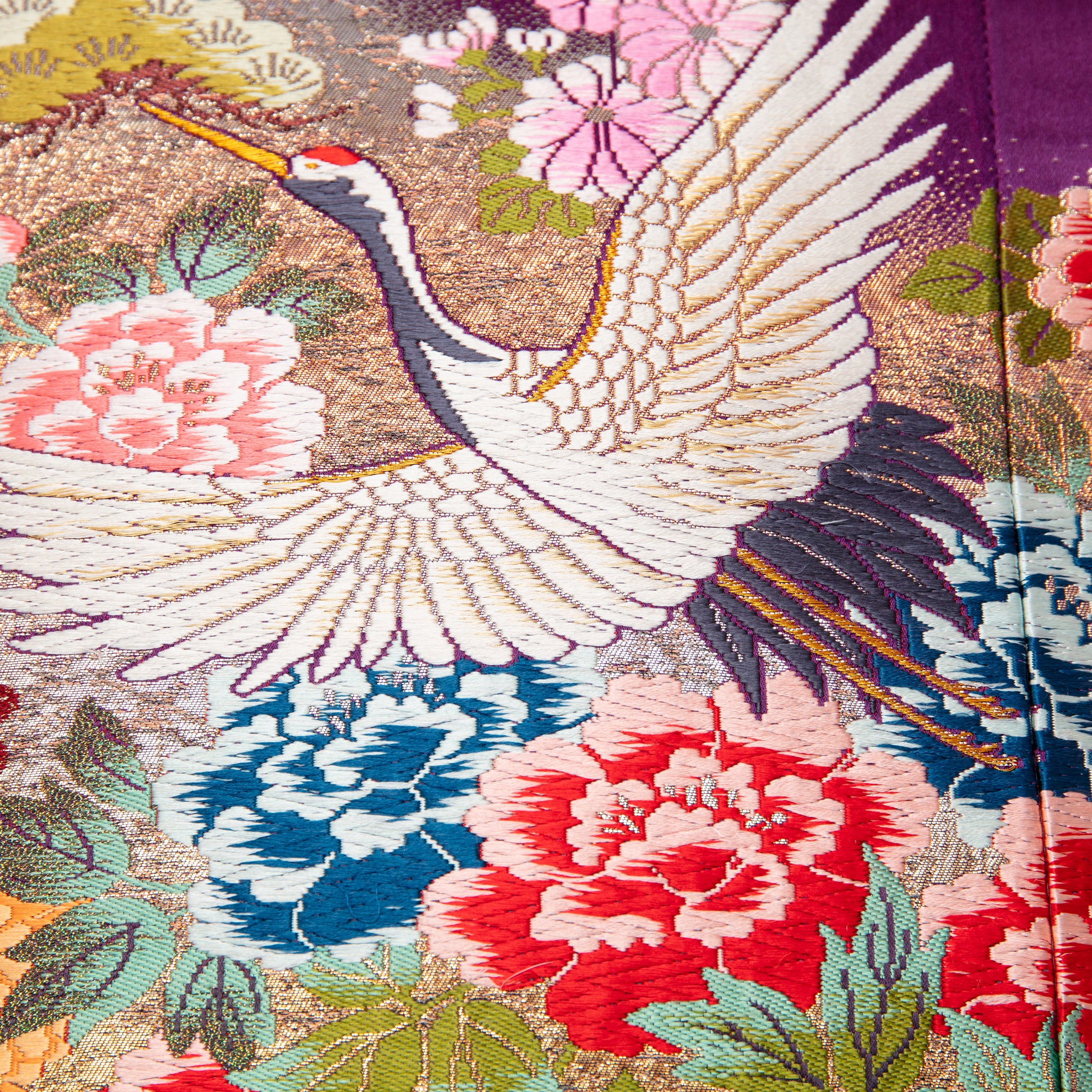 detail of vintage kimono silk pillow showing crane and floral embroidery