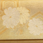 Close up of woven metallic gold silk flowers pattern on the front of a vintage Japanese silk clutch bag.