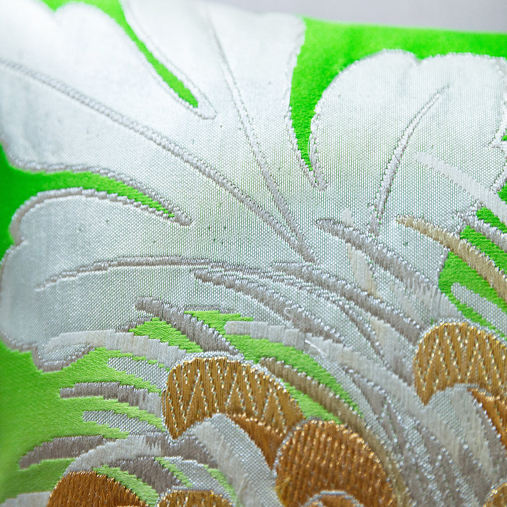 Close-up of the vibrant green floral embroidery detail on the Obi Silk Kiku cushion’s textured fabric surface.