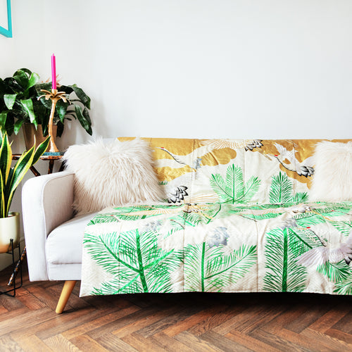 silk throw made from vintage kimono silk, cream base, green pines, gold clouds and cranes, on sofa