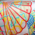 Close-up of golden yellow fabric with detailed embroidery of oriental fans on shimmering silver Kimono silk bolster cushion