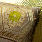 Close-up of the gold geometric pattern detail on the chartreuse velvet fabric, highlighting the intricate stitching and
