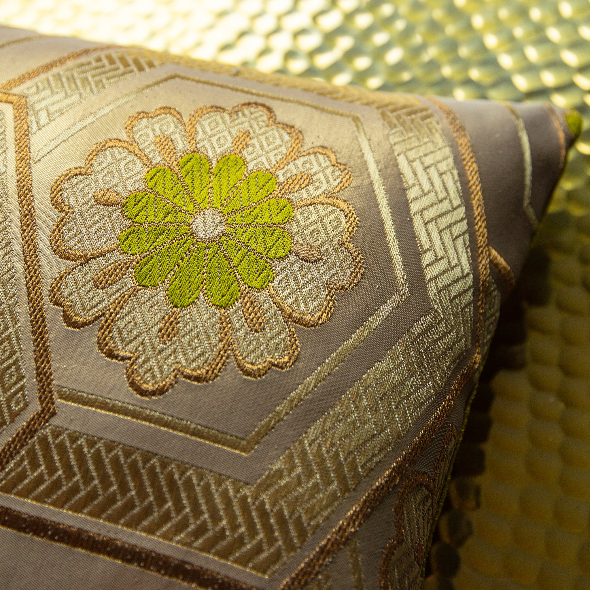 Close-up of the gold geometric pattern detail on the chartreuse velvet fabric, highlighting the intricate stitching and