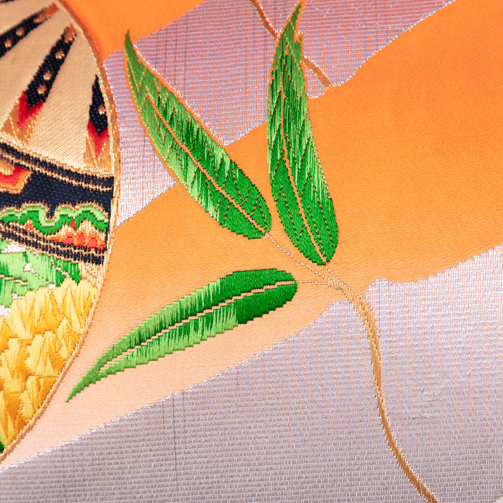 Close-up of the vibrant orange ombre silk fabric showcasing smooth texture and subtle sheen, with silver bamboo accents