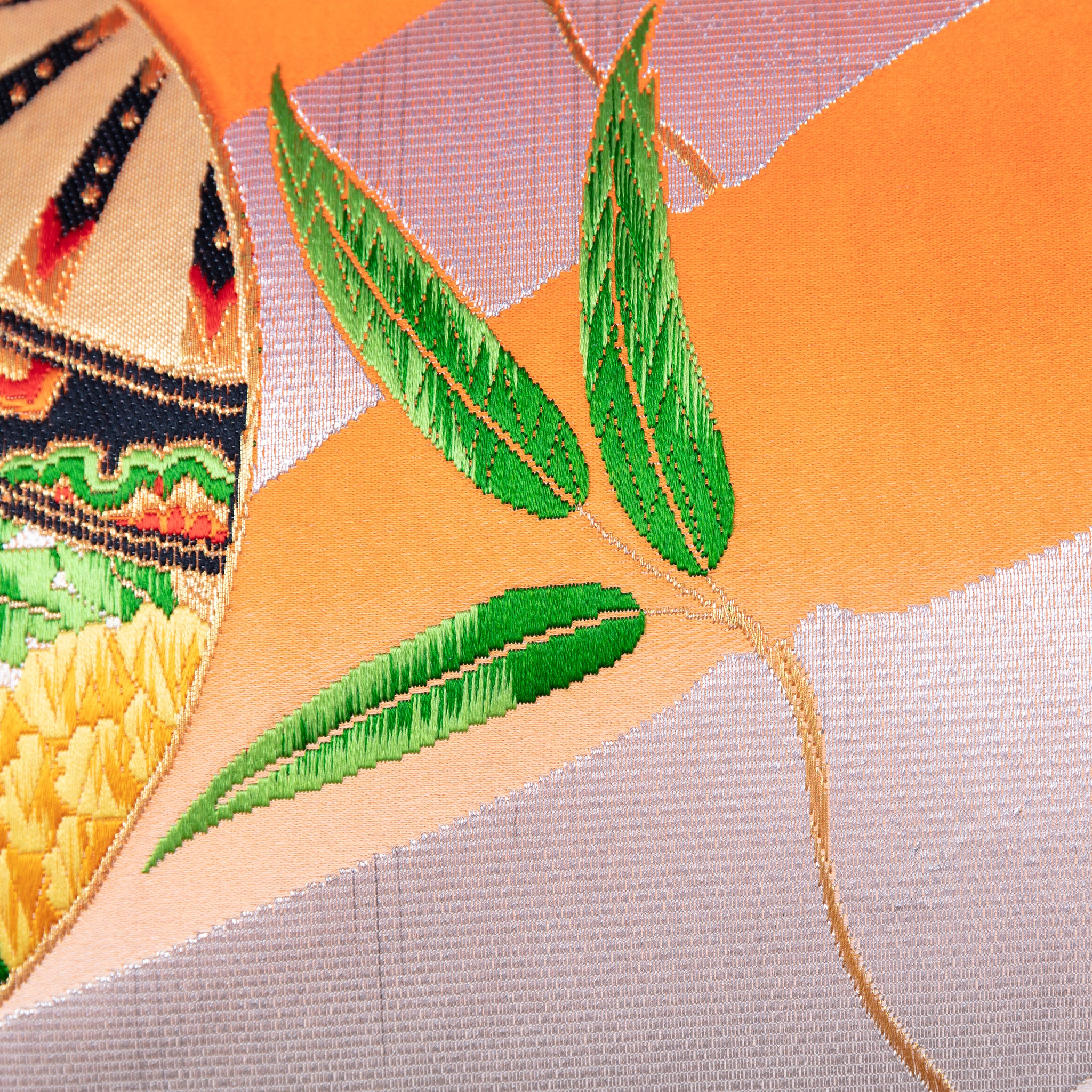 Close-up of the vibrant orange ombre silk fabric showcasing smooth texture and subtle sheen, with silver bamboo accents