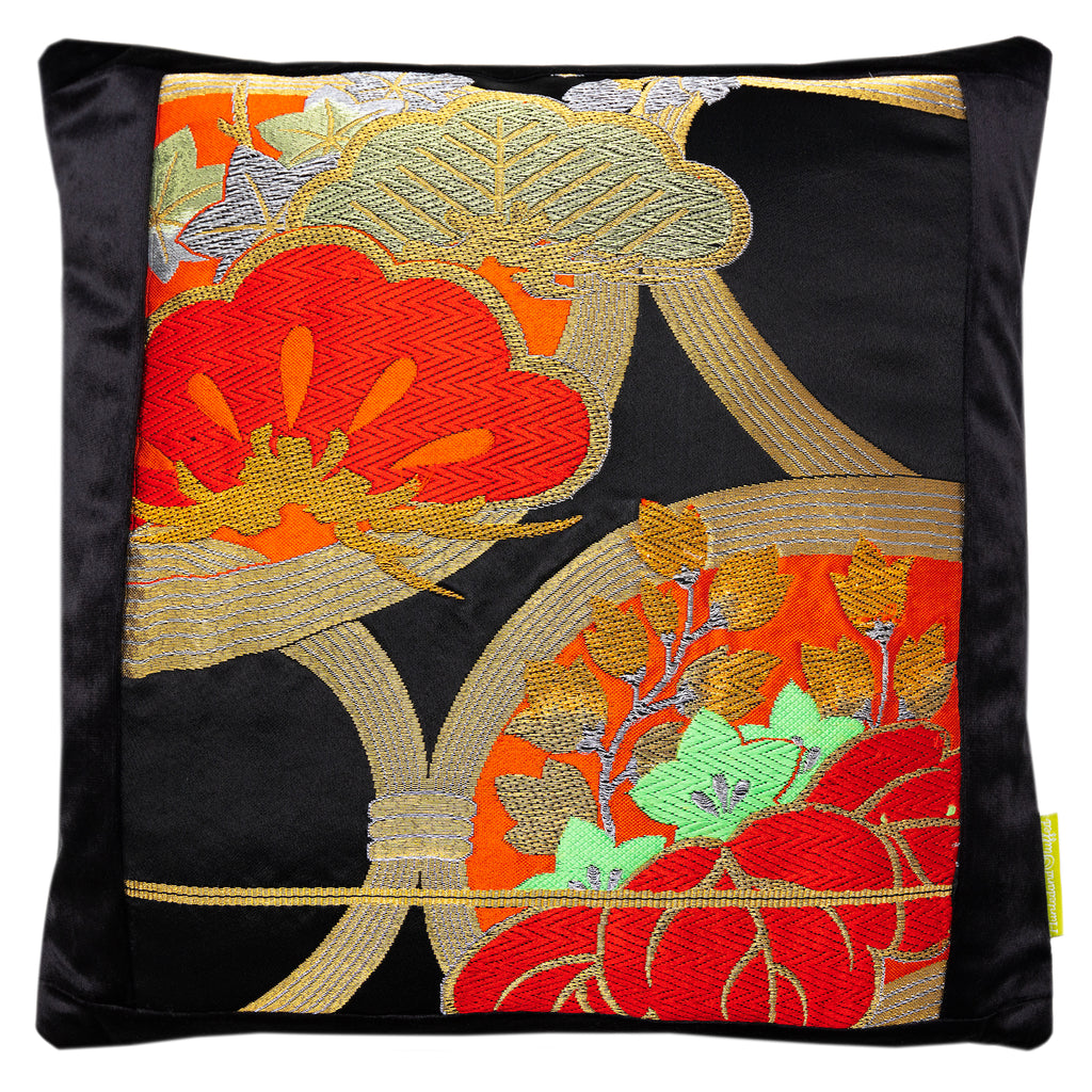 Close-up of red gold pine tree embroidery detail on the black velvet cushion fabric, highlighting rich texture and intricate