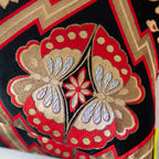 Detail of two butterfly symbols on a vintage black silk Japanese cushion.