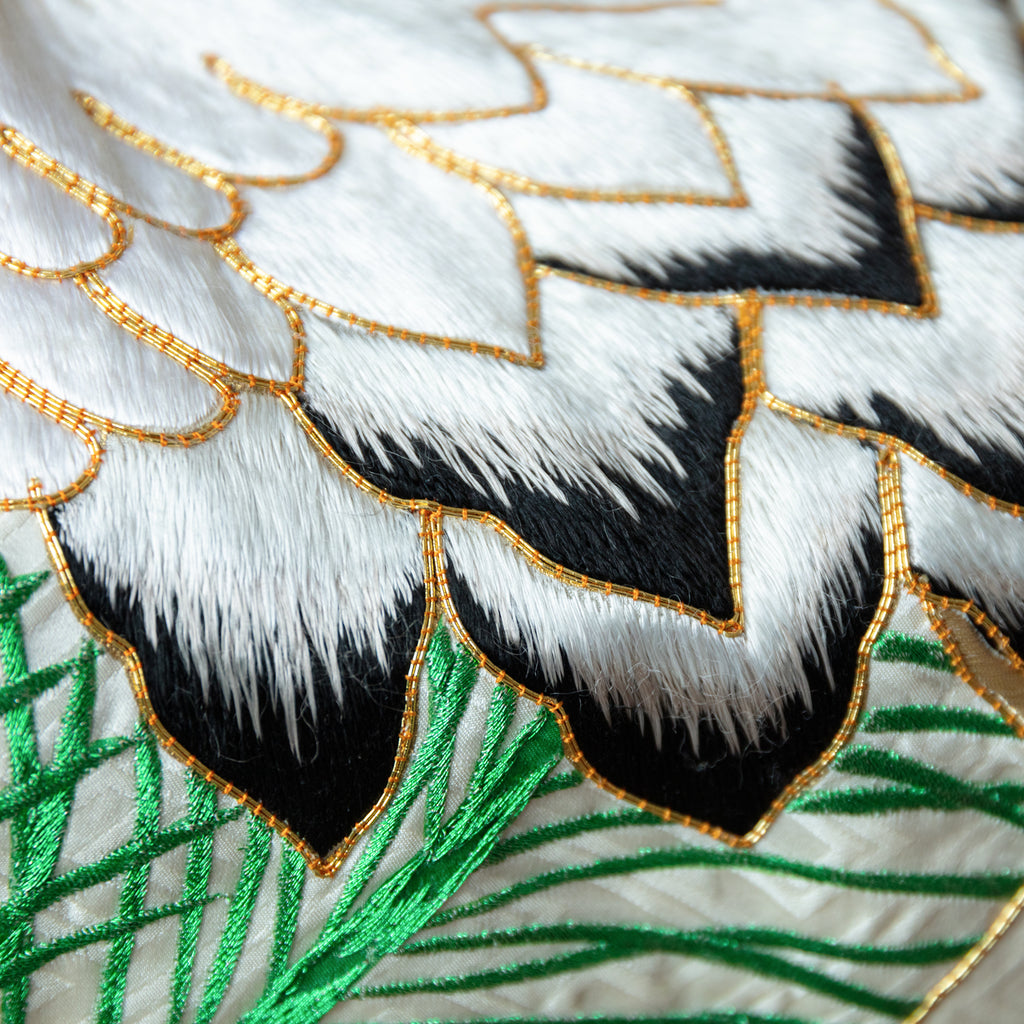 Close up of silk throw made from vintage uchikake kimono, crane tail embroidered in white and black with raised gold couchwork edges.