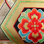 Close-up of woven vintage silk obi cushion with gilt thread zig-zags, hexagons and flowers.