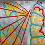 Close-up of silver Japanese obi bolster cushion with fan pattern embroidery made from vintage 1950s maru obi