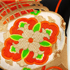 Close up of drum motif on a vintage silk obi in red and gold on black silk