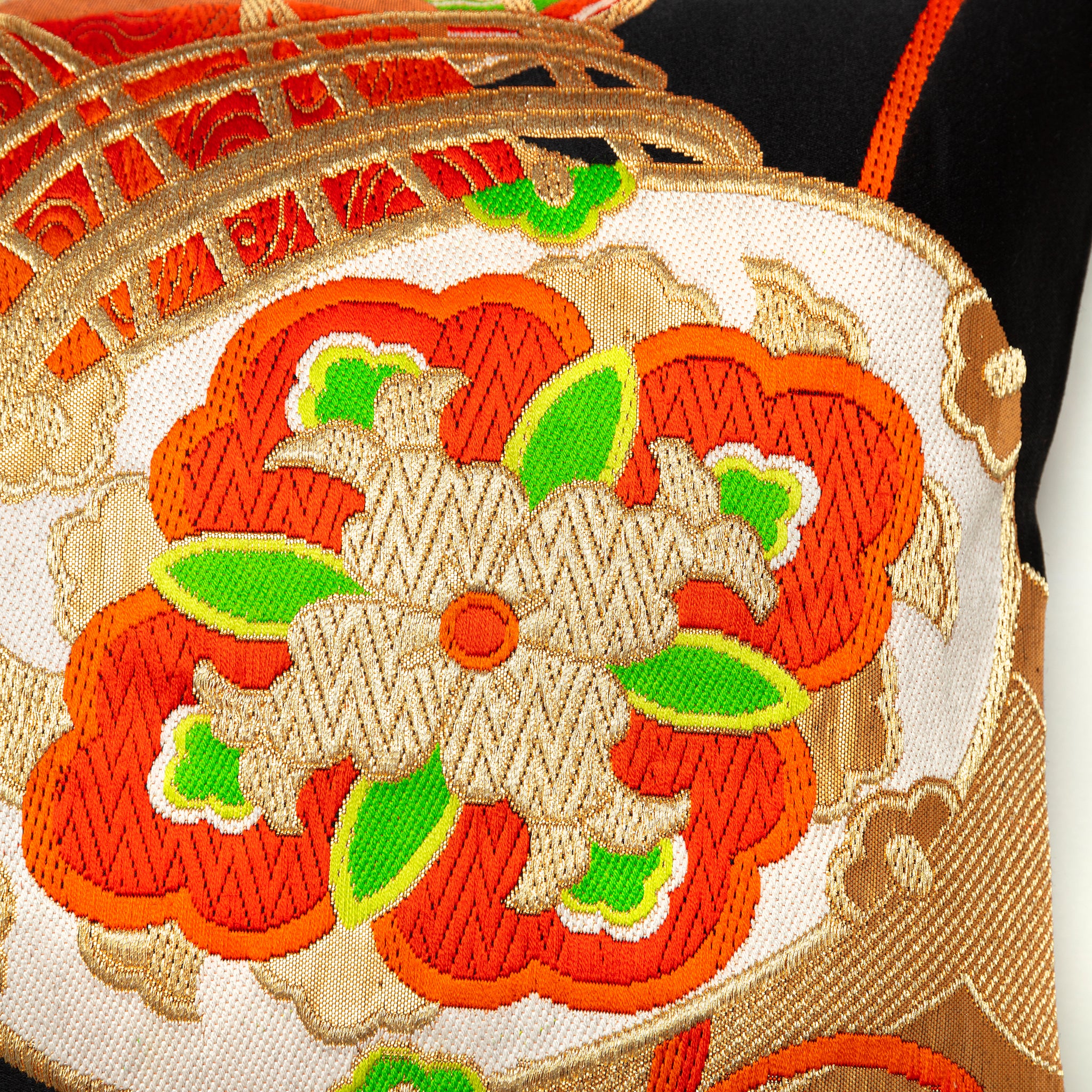 Close up of drum motif on a vintage silk obi in red and gold on black silk