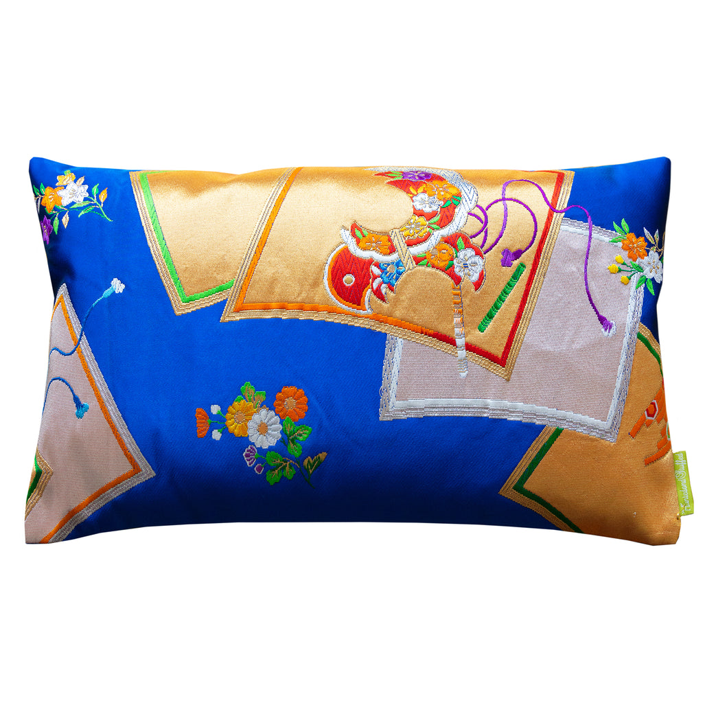 An electric blue silk pillow with gold accents featuring traditional Japanese patterns. Made from a vintage Japanese silk obi.