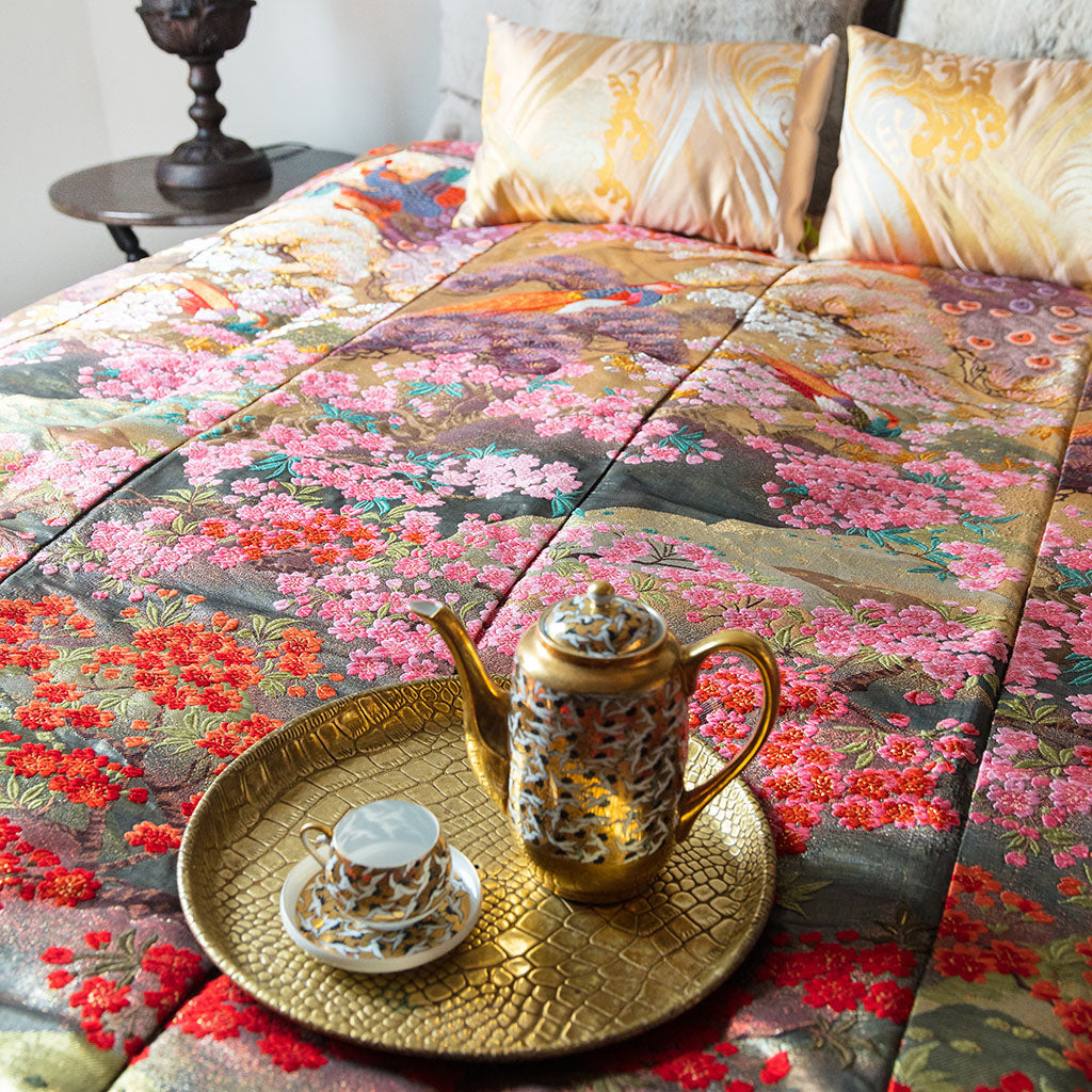 Close-up of the vintage kimono-inspired silk throw blanket’s intricate floral embroidery and vibrant color details on woven