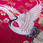 Close-up of pink crane embroidery highlighting delicate velvet and silk textures on the vintage Uchikake-inspired pillow
