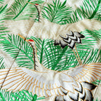Cream silk throw made from vintage uchikake kimono silk, two flying cranes in white over green pine needles embroidery, close up